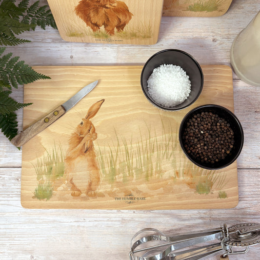Handmade rectangular chopping board featuring a watercolour Hare illustration, finished with blue ribbon.