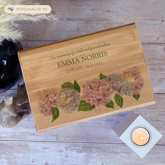A beautifully crafted solid Bamboo wooden urn, personalised and finished with a soft watercolour design of Hydrangeas and butterflies for the person who loved flowers and being in the Garden. Thoughtfully made for either display or burial, this personalised urn can be customised to create a meaningful memorial. Perfect for holding ashes of a loved one or a beloved pet, it serves as a comforting tribute and keepsake. 