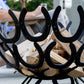 A large black log store handmade from recycled horseshoes. A close up shot of the horseshoes used to make the log store.