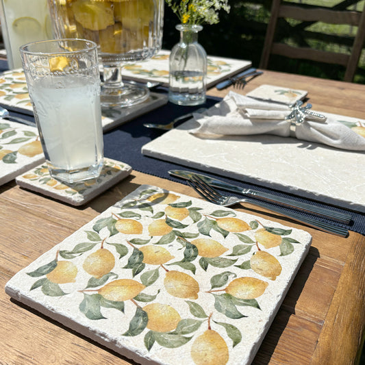A square medium multipurpose platter used as a side plate on an outdoor dining table. The platter features a maximalist lemon pattern.