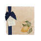 A medium multipurpose marble platter with a watercolour lemon design, packaged with a luxurious dark blue bow and branded gift tag.