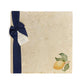 A large multipurpose marble platter with a watercolour minimalistic lemon design, packaged with a luxurious dark blue bow and branded gift tag.