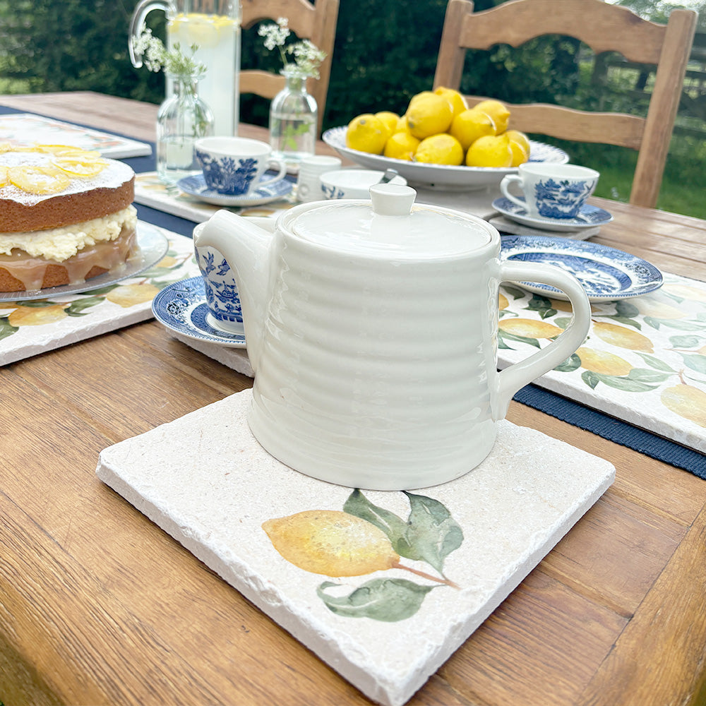 A marble teapot stand featuring a simple lemon watercolour design.