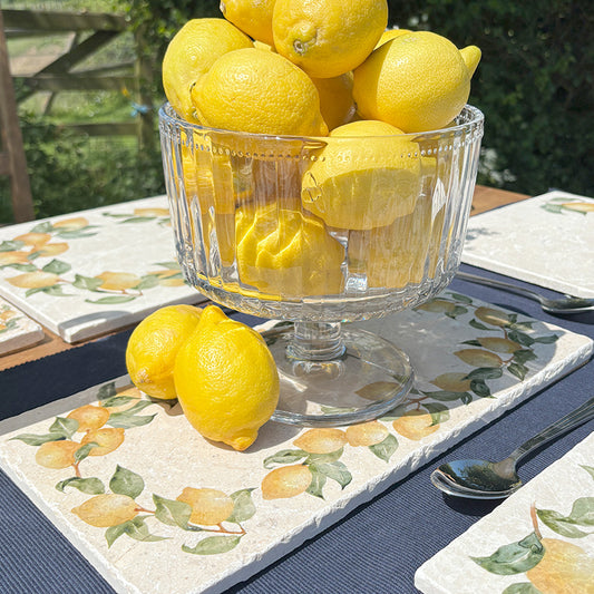 A garden table set with marble serving platters featuring a lemon wreath watercolour design. 
