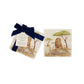 A pair of marble coasters with a watercolour lion and meerkat safari design. The coasters have a luxurious blue gift bow.
