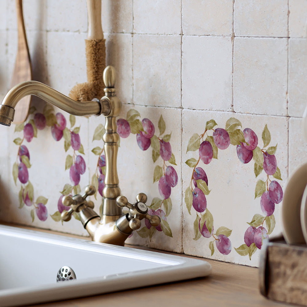 A rustic country kitchen sink with a splash back made up of 20x20cm marble tiles with a watercolour wreath design of plum branches.