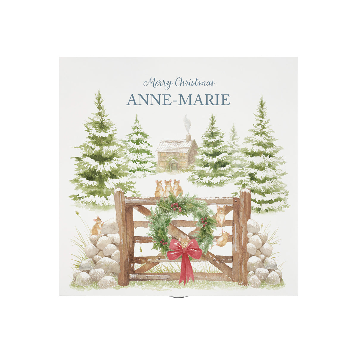 The top of a white wooden Christmas Eve gift box with a winter scene of mice playing on a cottage gate in a snowy forest watercolour illustration, the box is personalised with a name and Merry Christmas phrase.