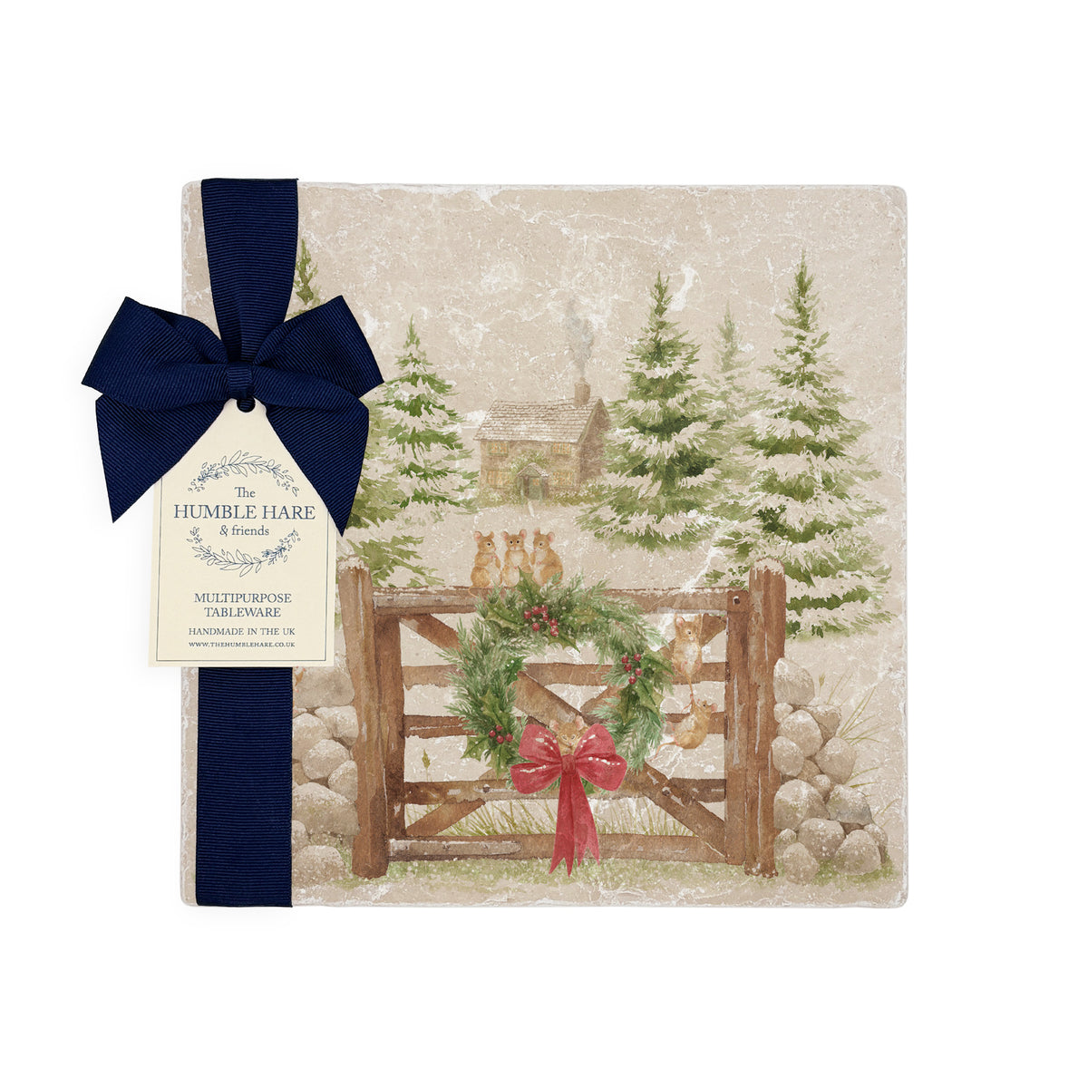 A square medium marble platter featuring a winter landscape watercolour illustration with snow-covered evergreen trees, a small cabin, mice playing on a wooden gate, a green wreath, and a red bow. The platter is wrapped in a dark blue bow with a paper tag.