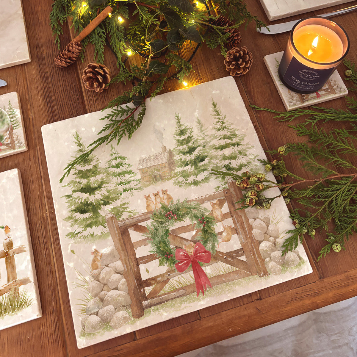 A large square marble platter with a watercolour winter forest scene featuring mice playing on the cottage gate. 