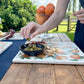 A large marble charcuterie board with a vibrant pattern of Mediterranean oranges and leaves. 