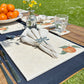 An elegant dining table set with marble placemats and coasters featuring a minimalistic orange design.