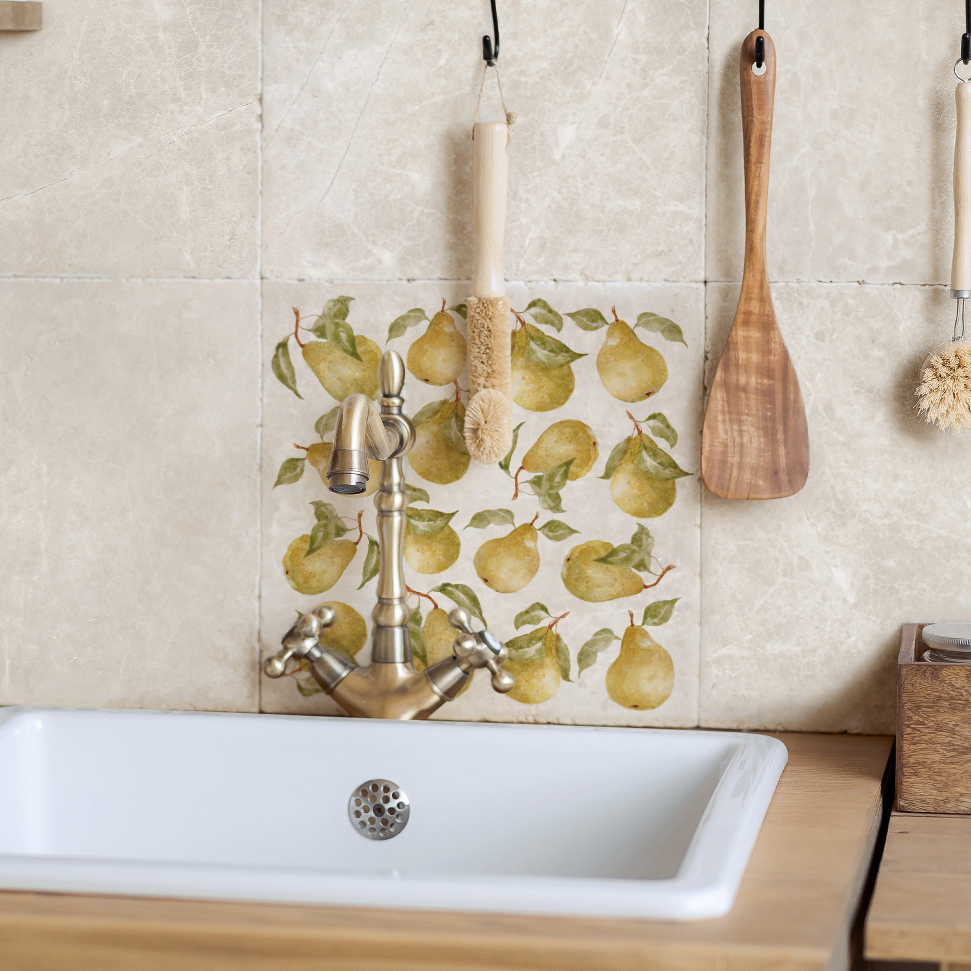 A large square marble splashback tile set behind a country kitchen sink. The tile has a pear pattern design.