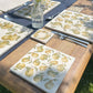 A square medium multipurpose platter used as a side plate on an outdoor dining table. The platter features a maximalist pear pattern.