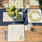 A garden tablescape set with handmade marble platters and coasters ready for a dinner party. The platters feature an elegant golden pear pattern.