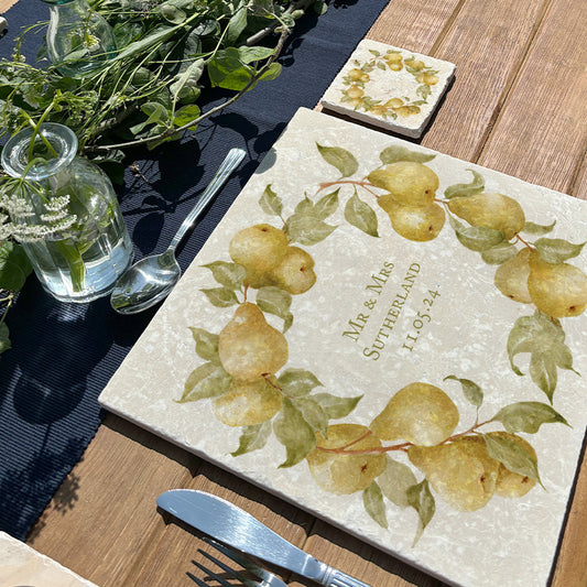 A large marble placemat personalised with a couple’s name and wedding date. The placemat is on a dining table set for entertaining.