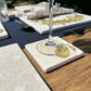 A square marble coaster on a garden table featuring a minimalistic watercolour pear design.