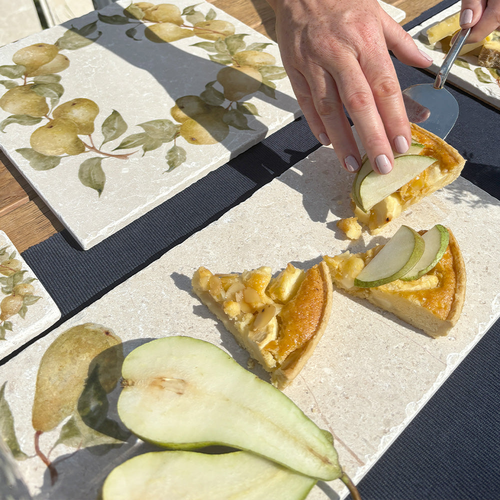 A marble sharing board being used to serve a pear tart. The Platter features a minimalistic watercolour design of a single pear with leaves.