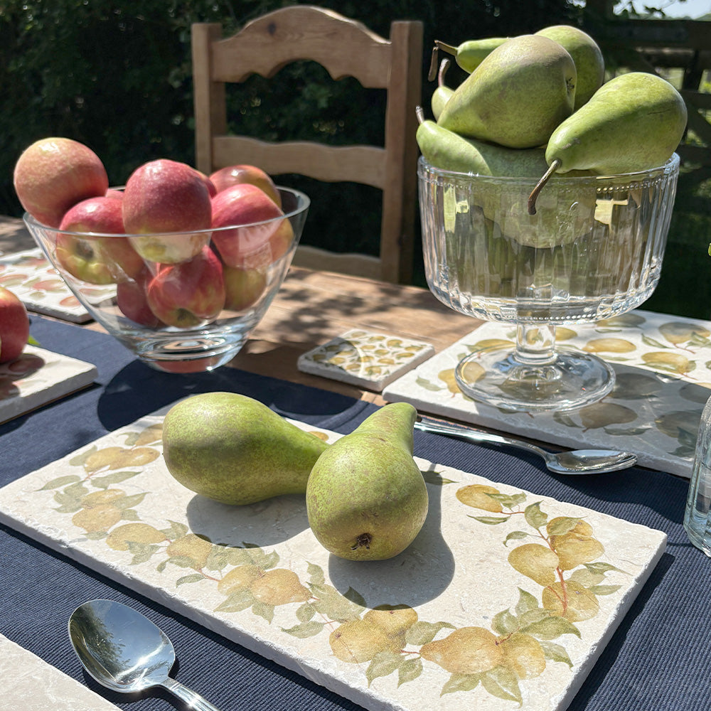 A garden table set with marble serving platters featuring a watercolour wreath of pear branches.