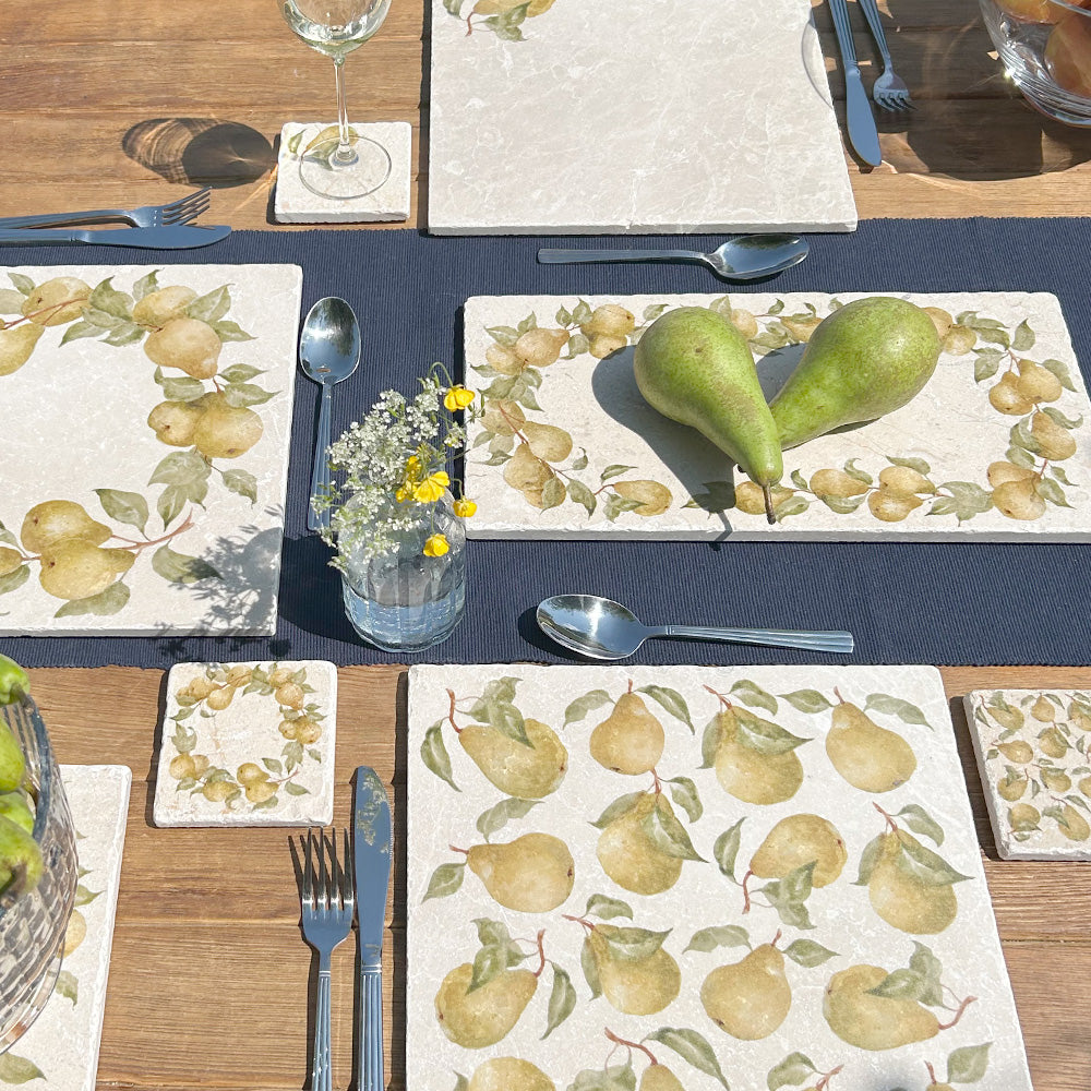 A sunny garden table set with handmade marble platters and coasters featuring a watercolour design in a vintage pear wreath style.