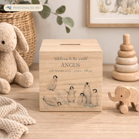 handmade nursery keepsake money box with delicate watercolour design, a group of Penguins playing, slipping and sliding in the snow. 