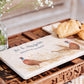 A pheasant personalised marble sharing platter being used to serve breakfast pastries on a tray. The platter is personalised with a couple's married name and 'Welcome to our kitchen' in dark blue text.
