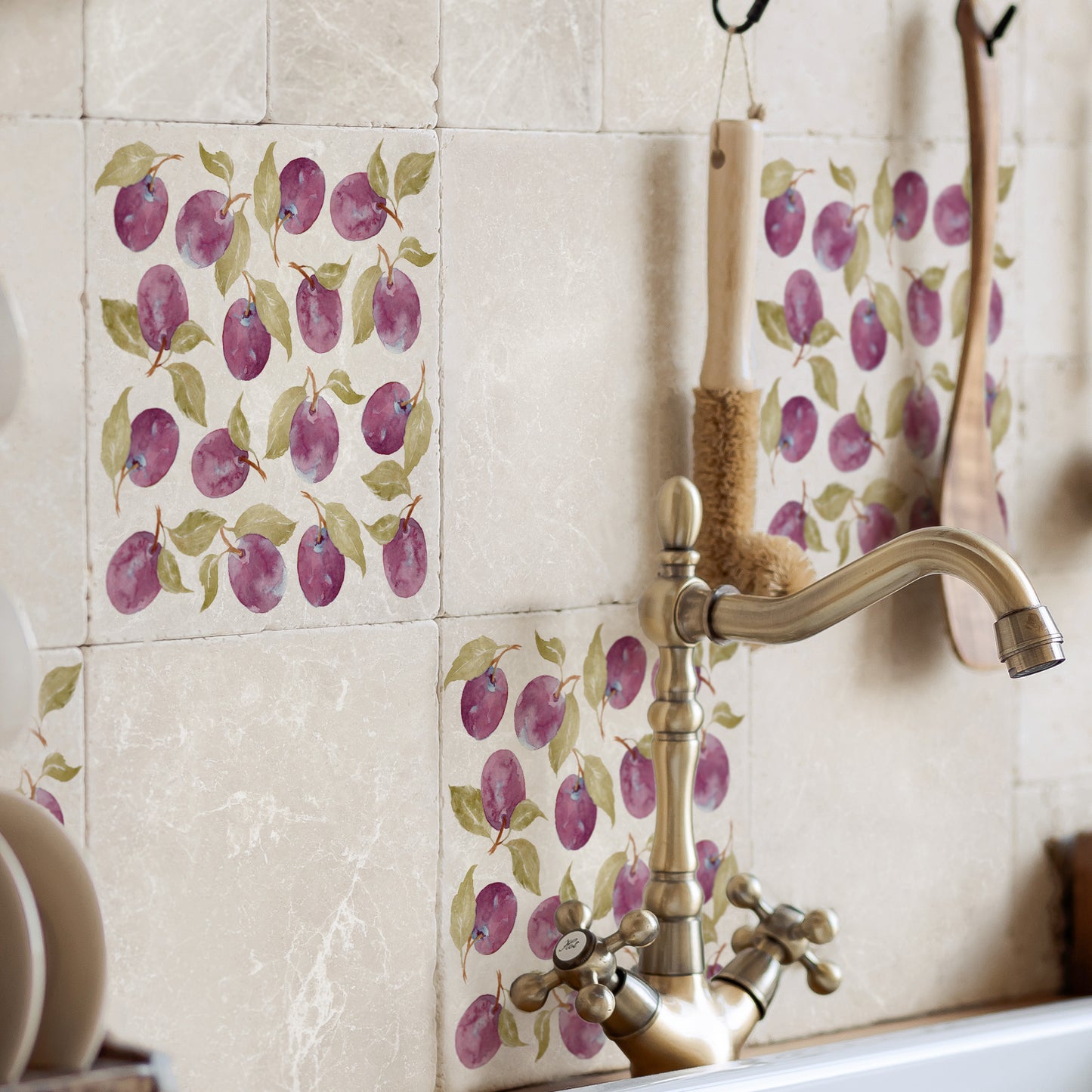 Square marble splashback tiles featuring a plum pattern, behind the sink in a country kitchen.