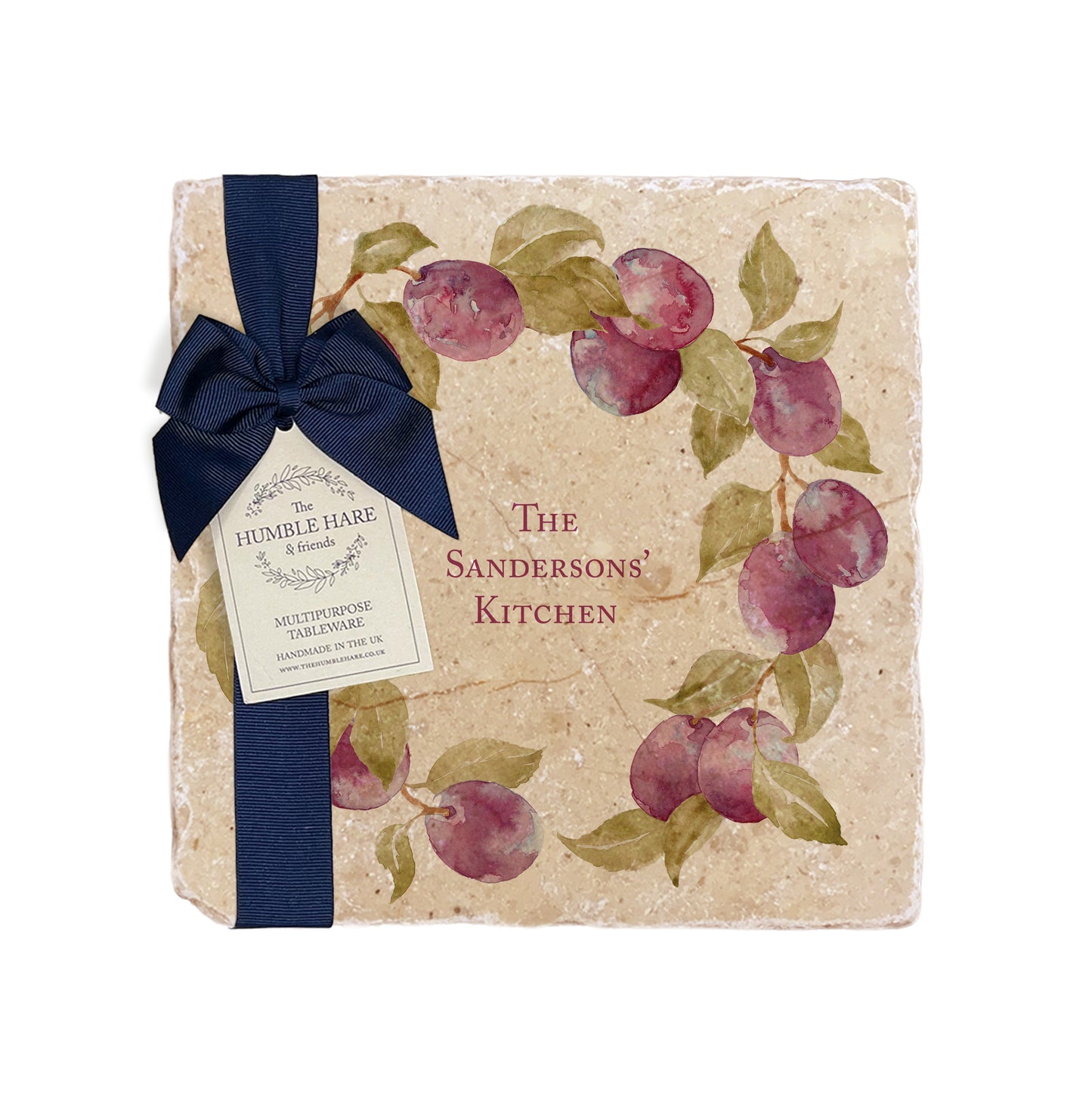 A personalised marble platter featuring a wreath of plums and leaves, with a bespoke message in the centre of the design. The platter is packaged with a luxurious blue gift bow and tag.