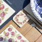 A square marble coaster featuring a watercolour plum wreath.