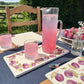 A garden table set with marble serving platters featuring a watercolour wreath of plum branches.