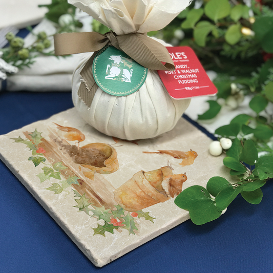 A medium marble platter set on a Christmas dinner table. The platter features a Christmas design of robins and holly.