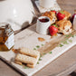 A personalised marble platter featuring a robin design set with scones, jam and fruit ready for an afternoon tea.