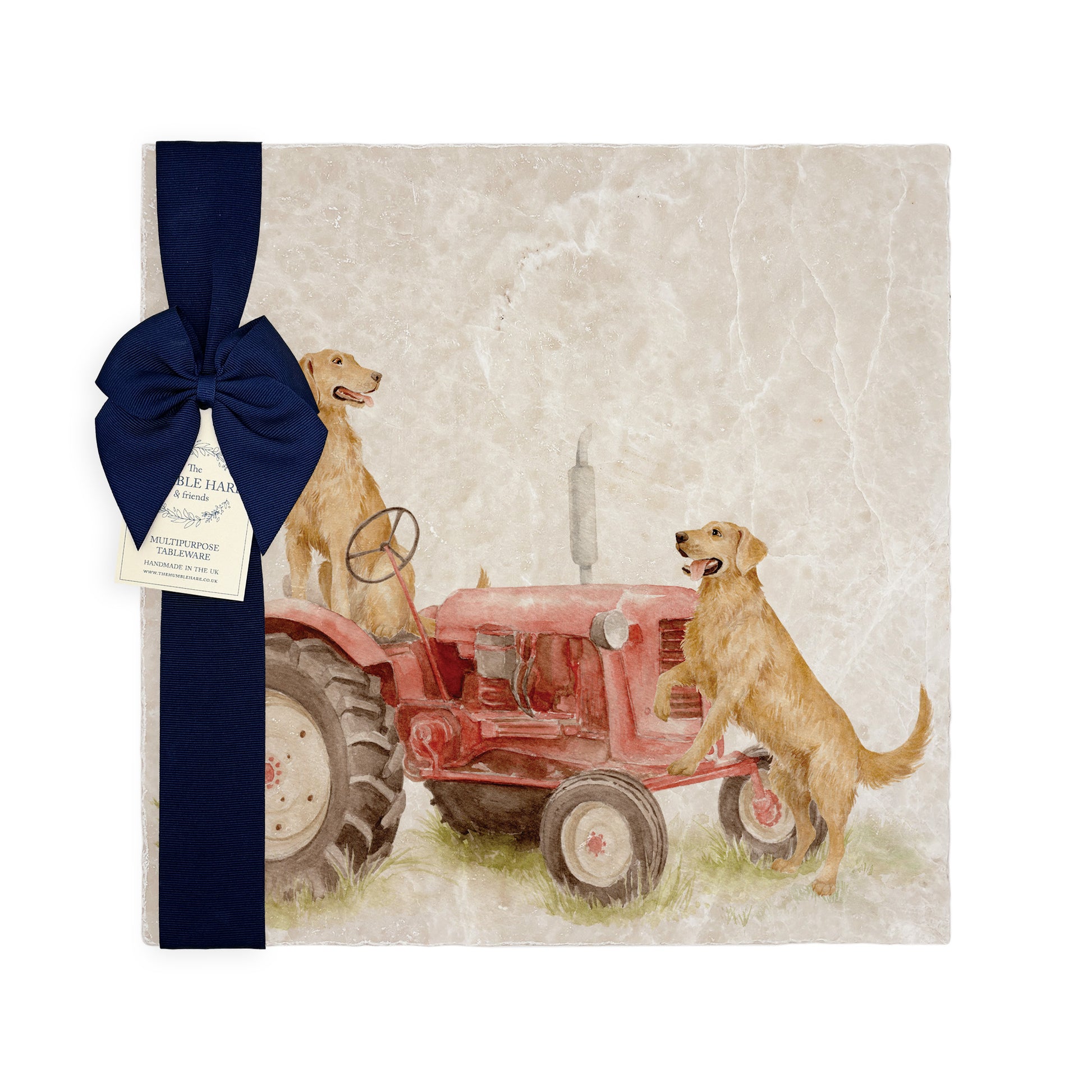 A square large marble platter featuring a watercolour design of working retriever dogs sat on a vintage red tractor. The platter is packaged with a luxurious blue gift bow.