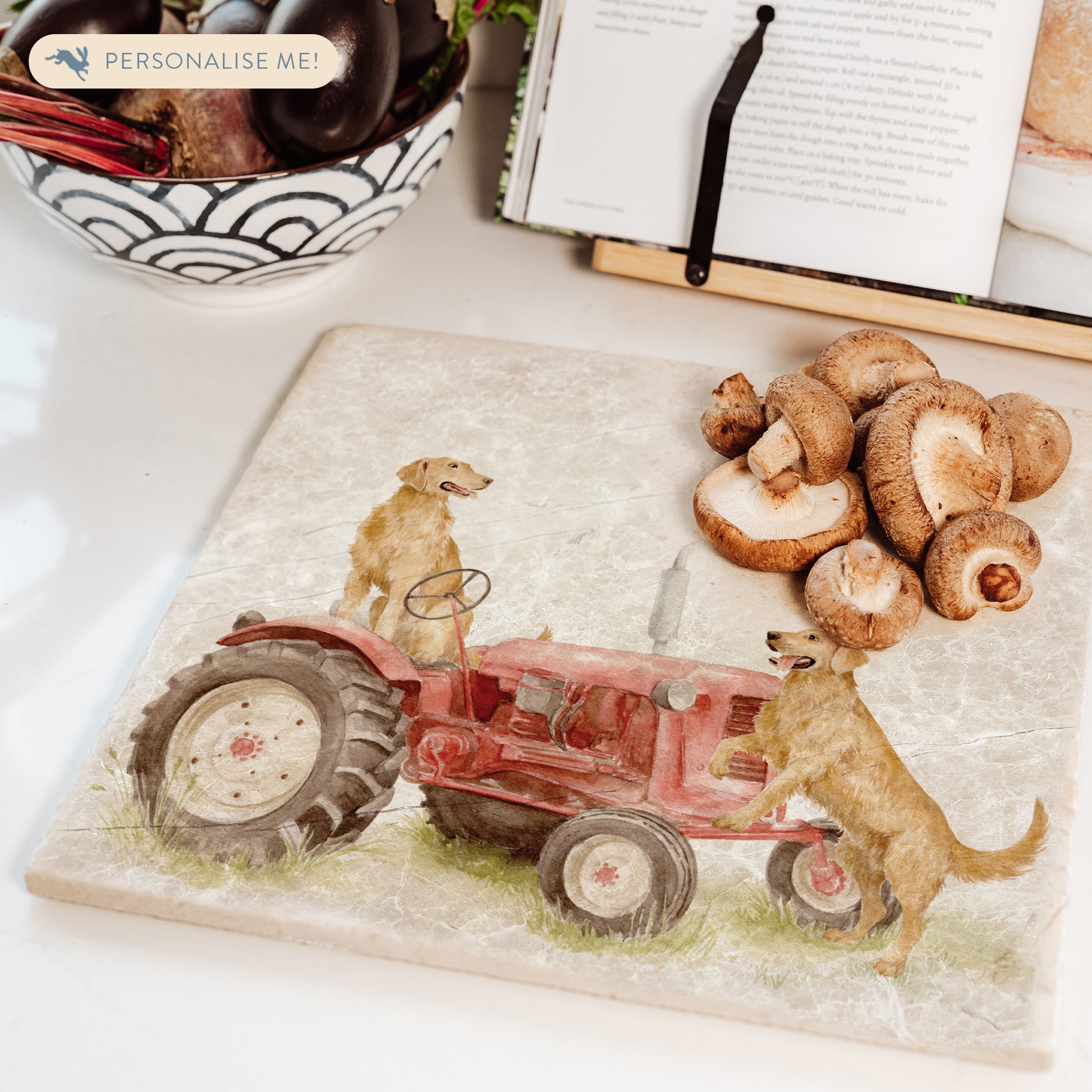 A square large marble platter with golden retriever dogs sat on a vintage red tractor. The marble platter is sat on a farmhouse kitchen worktop.