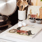 A square large marble platter with black flat-coated retriever dogs sat on a vintage red tractor. The marble platter is sat on a farmhouse kitchen worktop.