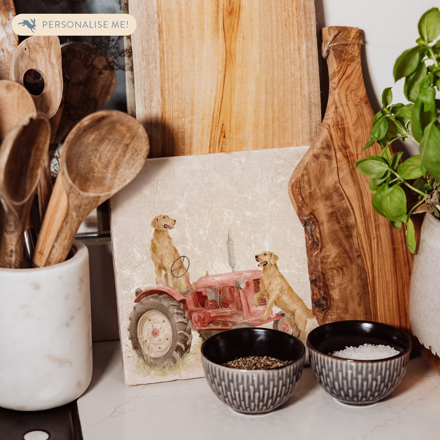 A square medium marble platter with golden retriever dogs sat on a vintage red tractor. The marble platter is sat on a farmhouse kitchen worktop.