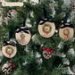 Four oval marble Christmas ornaments hanging on a Christmas tree featuring a robin sitting on a green wreath, with personalised text written below. The ornaments have luxurious velvet ribbon and bow hanging loops.