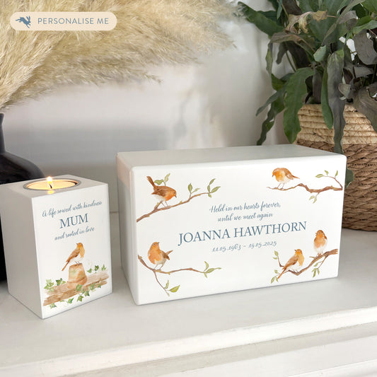 A beautifully crafted solid wooden urn, finished in white with a soft watercolour design of Robins of Branches, Thoughtfully made for either display or burial, this personalised urn can be customised to create a meaningful memorial. Perfect for holding ashes of a loved one or a beloved pet, it serves as a comforting tribute and keepsake.