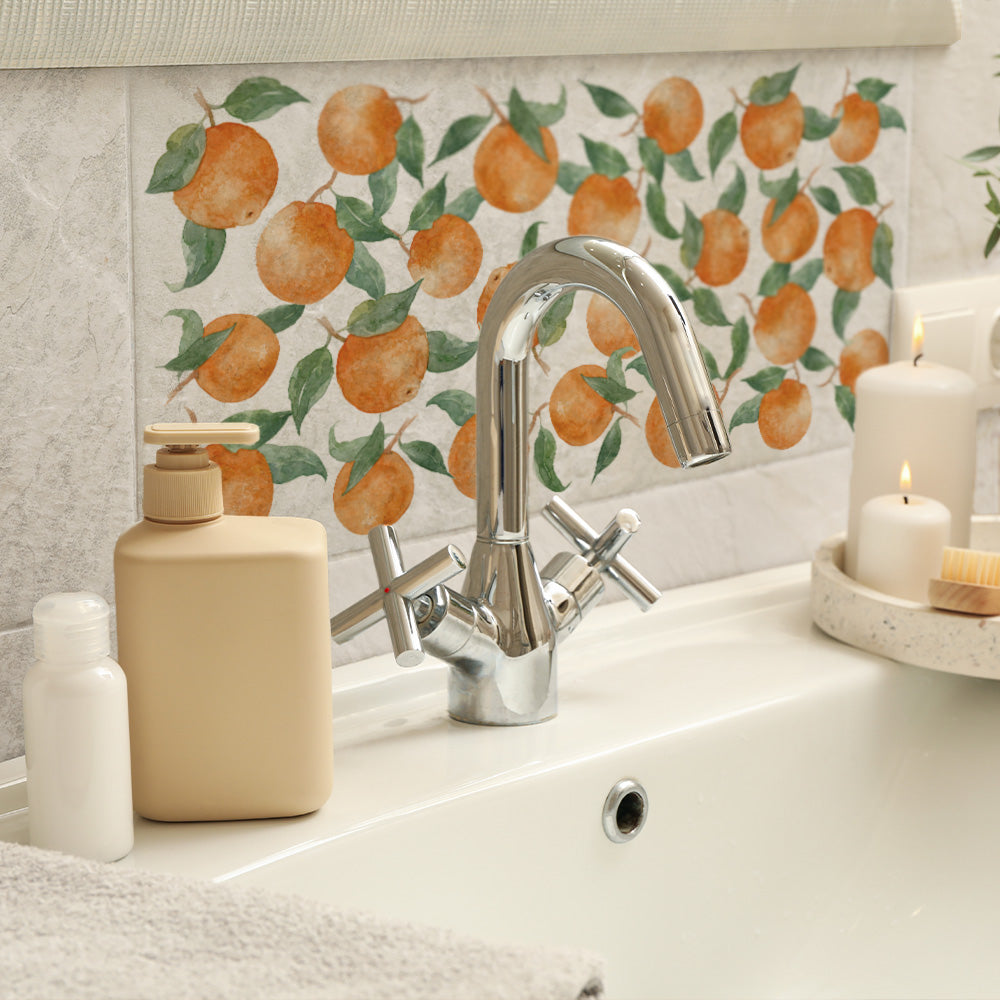 A luxurious bathroom sink with a 20x40cm cream marble splash back tile with a watercolour oranges and leaves pattern.