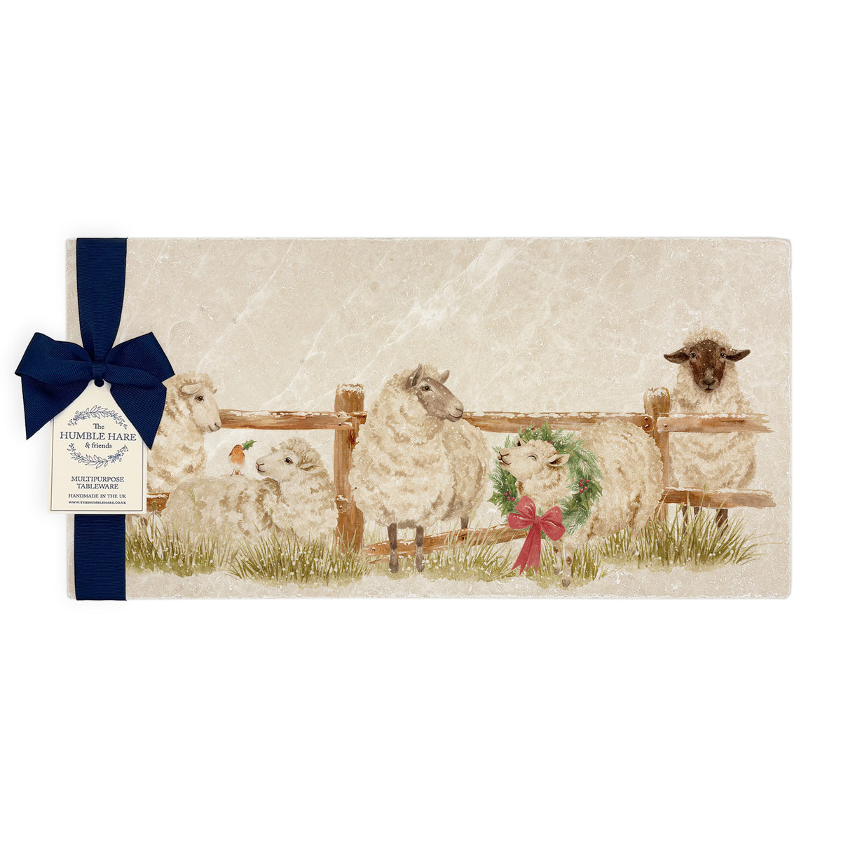 A rectangular marble sharing platter featuring a farmyard scene of sheep in the snow wearing a Christmas wreath. The platter is wrapped with a navy blue gift bow and paper tag.