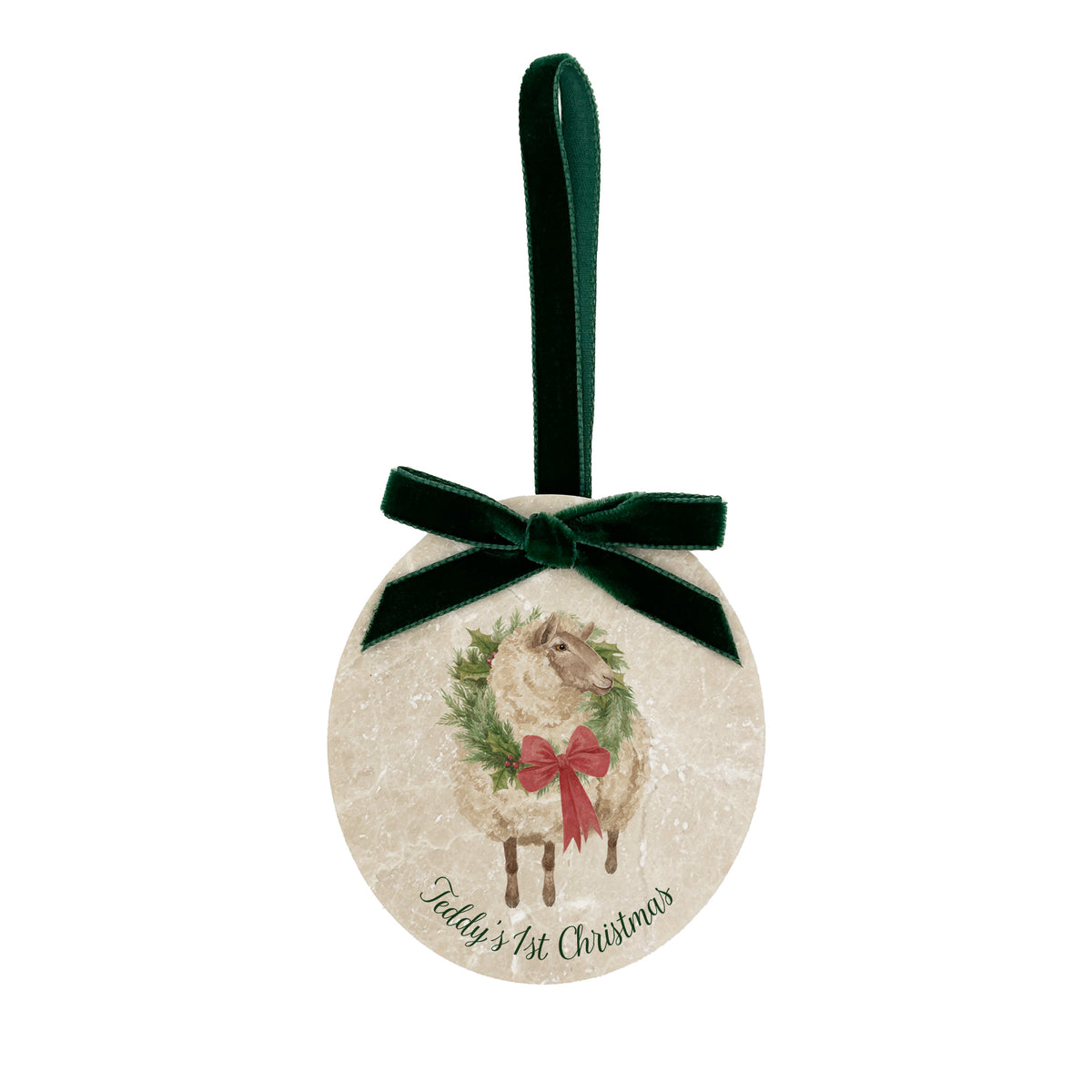 An oval marble Christmas ornament featuring a sheep wearing a green wreath, with personalised text reading 'Baby's 1st Christmas' written below. The ornament has a dark green velvet ribbon and bow hanging loop.