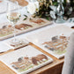 A wooden dining table set with cream marble placemats and coasters. The placemats are square and feature some cheeky silly Shetlands in a watercolour style.