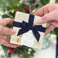 A pair of marble coasters featuring a noble stag design being given as a gift, packaged with a luxurious blue bow and tag.