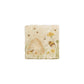 A 10x10cm cream marble splashback tile with a watercolour design featuring a beehive and bees in a buttercup meadow.