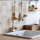 A rustic country kitchenwith a cream marble tile wall behind the kitchen sink. The tiles are an alternating pattern of plain tiles and tiles featuring a watercolour bee design.