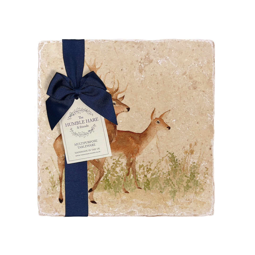 A medium square marble cheese board with a red deer stag and hind watercolour design, packaged with a luxurious dark blue bow and branded gift tag.