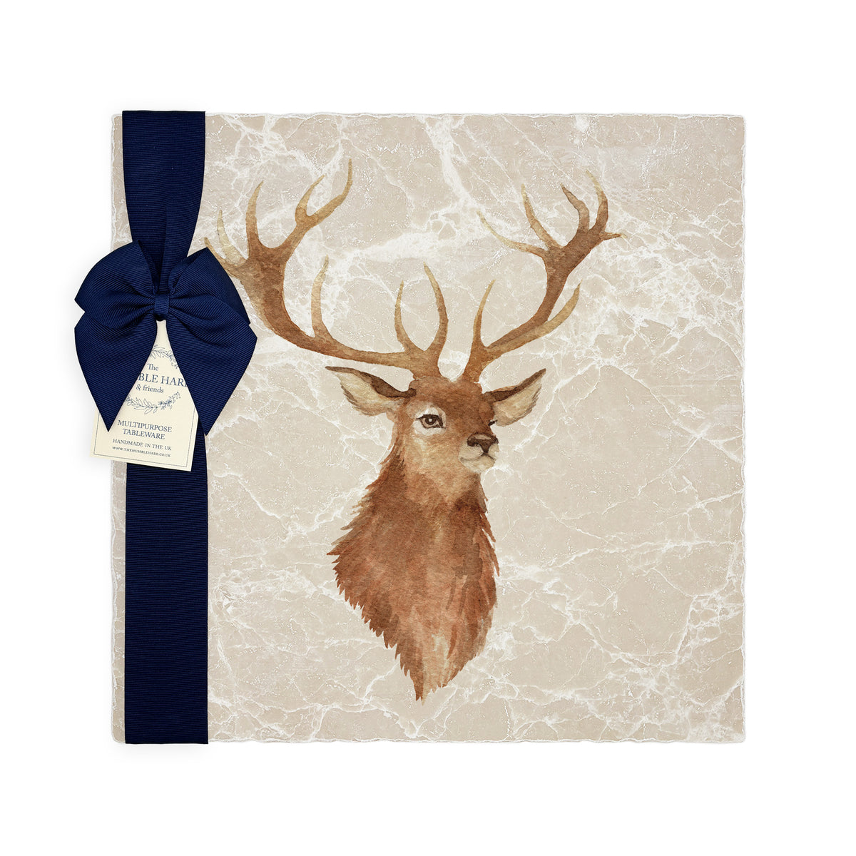A large square marble platter featuring a watercolour portrait of a majestic stag. The platter is packaged with a navy blue gift bow and paper tag.
