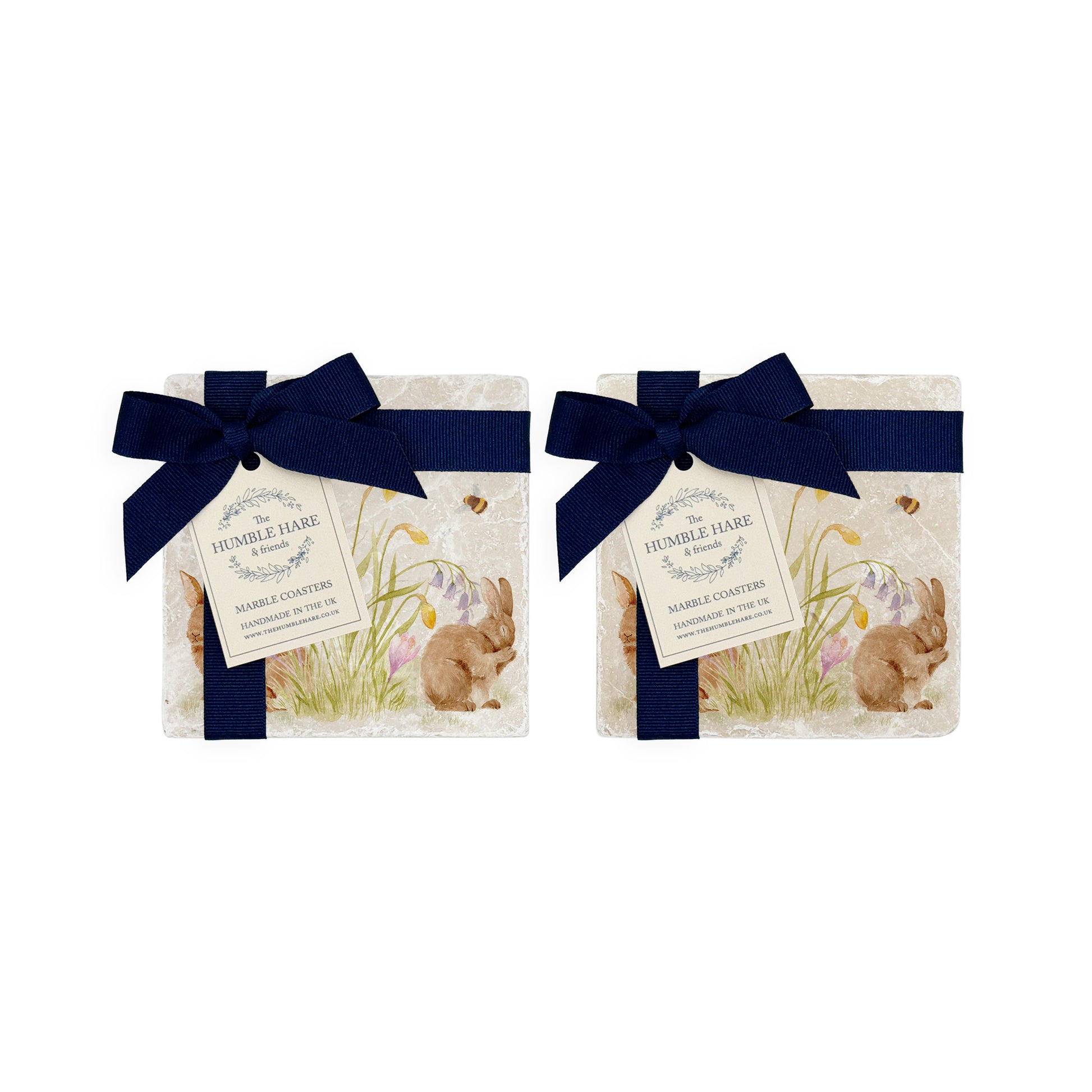 A set of four marble coasters with a watercolour design of spring flowers and cute fluffy bunnies. The set is bowed in two pairs with luxury blue bows and gift tags.