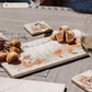 A rectangular cream marble sharing platter, featuring a watercolour design of a fox with two fox cubs playing in grass. The marble platter is personalised with dark blue text at the top, reading Uncle Fred's Cheese & Biscuits.