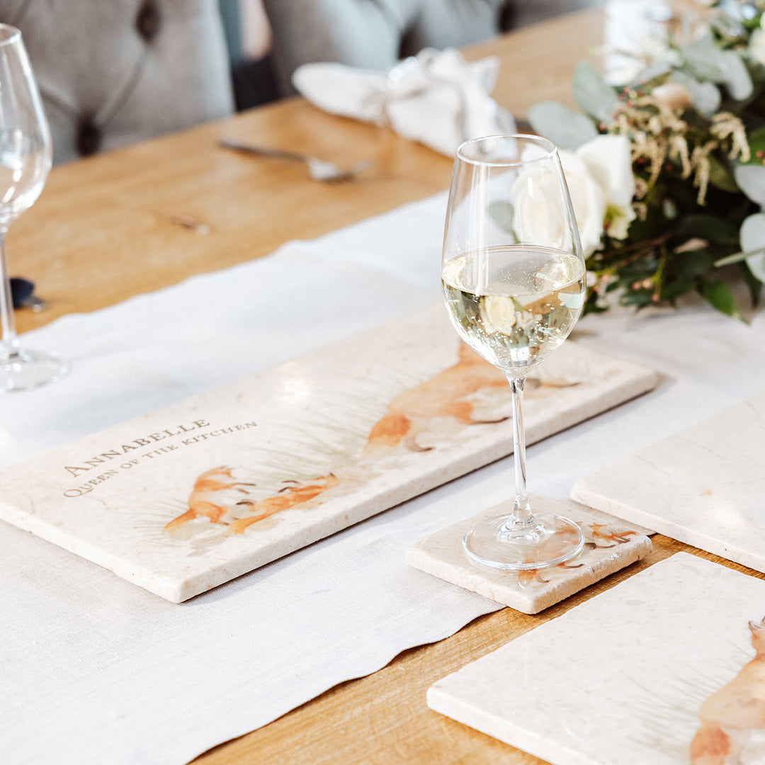 A personalised marble sharing platter featuring a watercolour fox family design displayed on an elegant country house dining table.