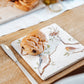 A medium multipurpose marble platter with a watercolour design featuring British garden birds on branches. The platter is being used as a plate for breakfast pastries.